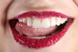 Person mit rotem Lippenstift und weißen Zähnen